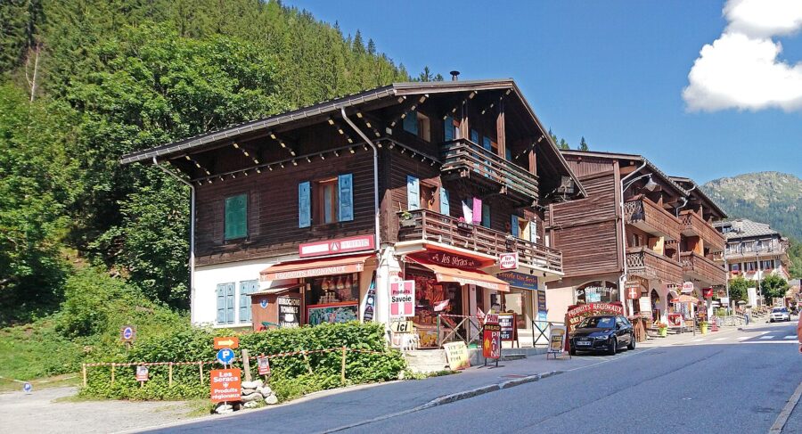 Charming street with shops and majestic mountains rising in the background, capturing the essence of Argentiere, France.