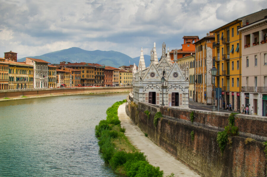 Scenic view of the Arno River in Pisa, featuring the gothic cathedral Santa Maria della Spina along the riverbank