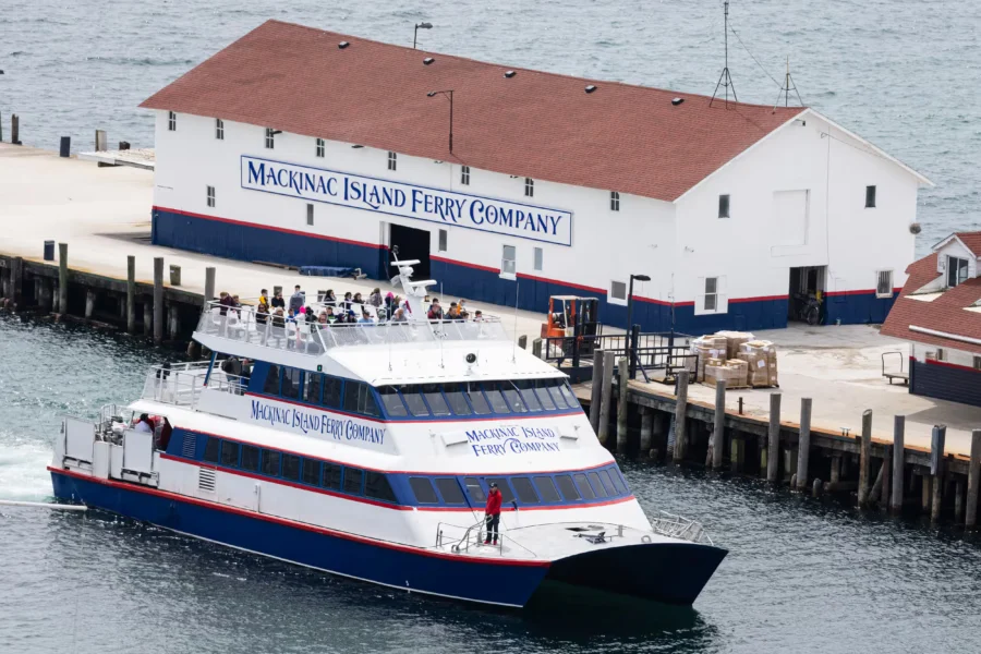 Arnold Transit Company ferry boat transporting passengers across clear blue waters near Mackinac Island.