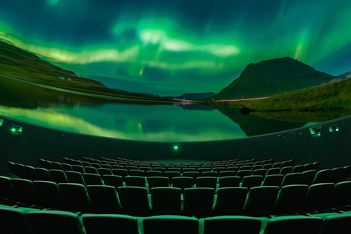 The aurora borealis illuminates the night sky over Iceland, viewed from the Áróra Northern Lights Planetarium Show seats.