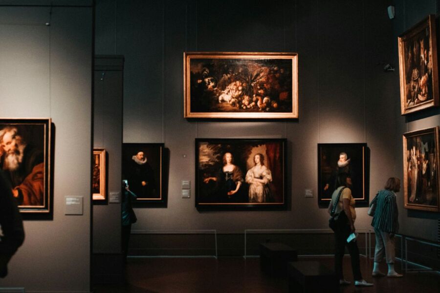 Visitors explore diverse artworks in a modern art gallery.