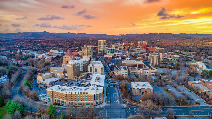 Sunset over Asheville, North Carolina, showcasing vibrant colors illuminating the sky and silhouetting the mountains.