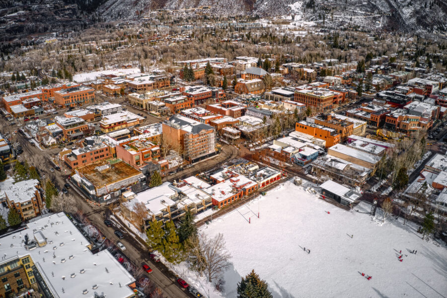 Winter aerial view of a famous Colorado ski town, featuring snow-covered slopes and charming alpine architecture
