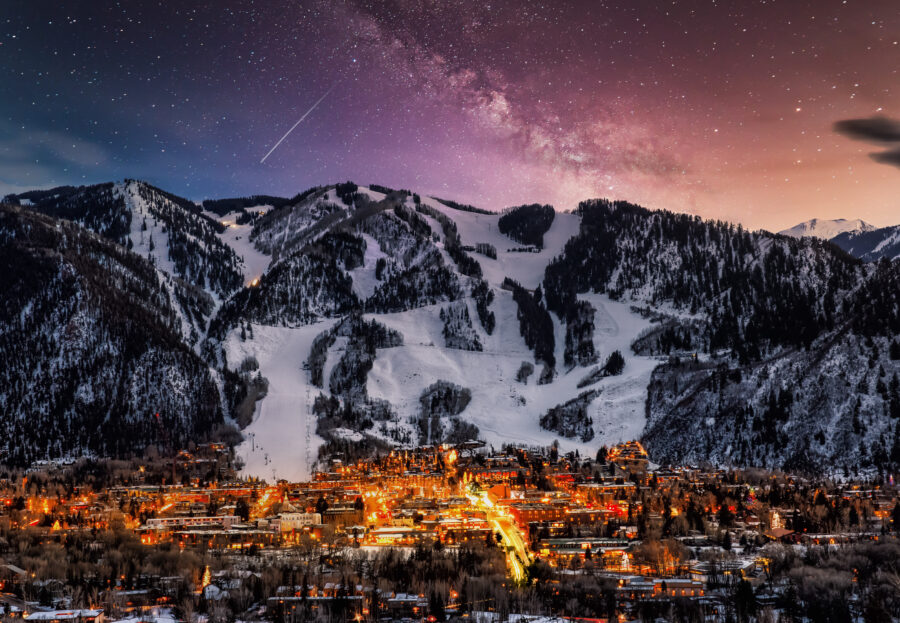 Night view of Aspen's skyline, featuring lit buildings and a serene atmosphere under a starry sky