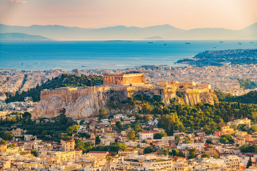 Panoramic aerial view of Athens, Greece, showcasing a vibrant sunset over the city on a summer day