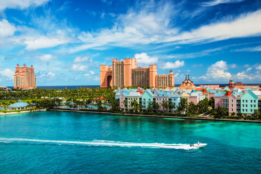 Scenic view of Nassau, Bahamas, featuring a vibrant landscape and a speedboat gliding through the clear blue waters