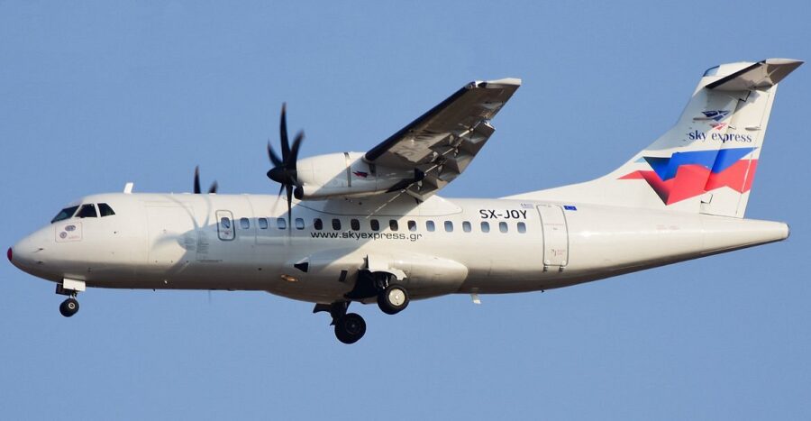 Sky Express ATR 72 aircraft SX-JOY in flight against a clear blue sky.