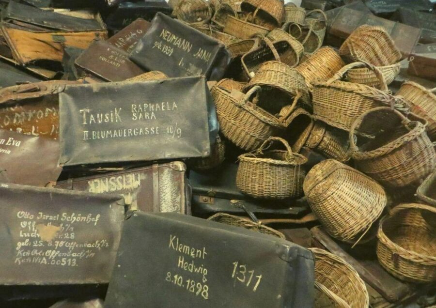 Stack of vintage wicker baskets alongside assorted items, part of the Auschwitz-Birkenau Memorial and Museum Exhibit.