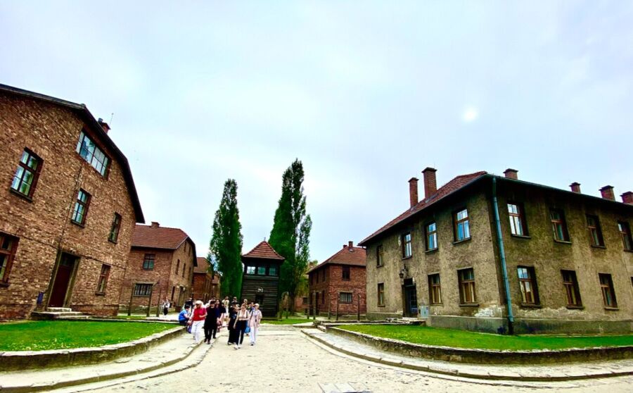 Courtyard of Auschwitz I Barracks, a former concentration camp in Poland, featuring historical buildings and somber atmosphere.