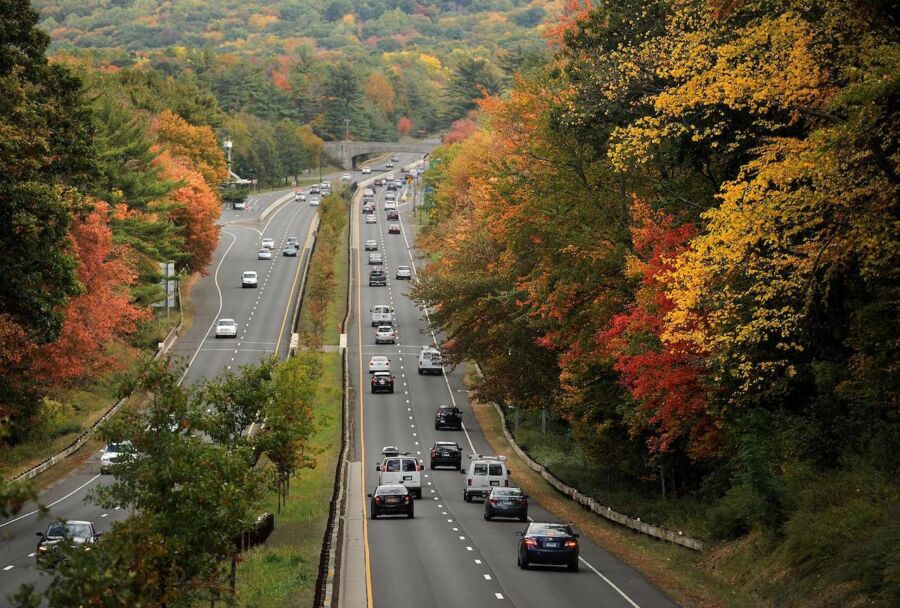 A scenic autumn highway with vibrant foliage, rolling hills, and a mild, pleasant day.