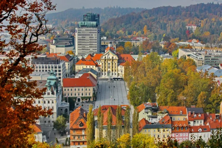Autumn aerial view of a European town square with red roofs and historic classical building.