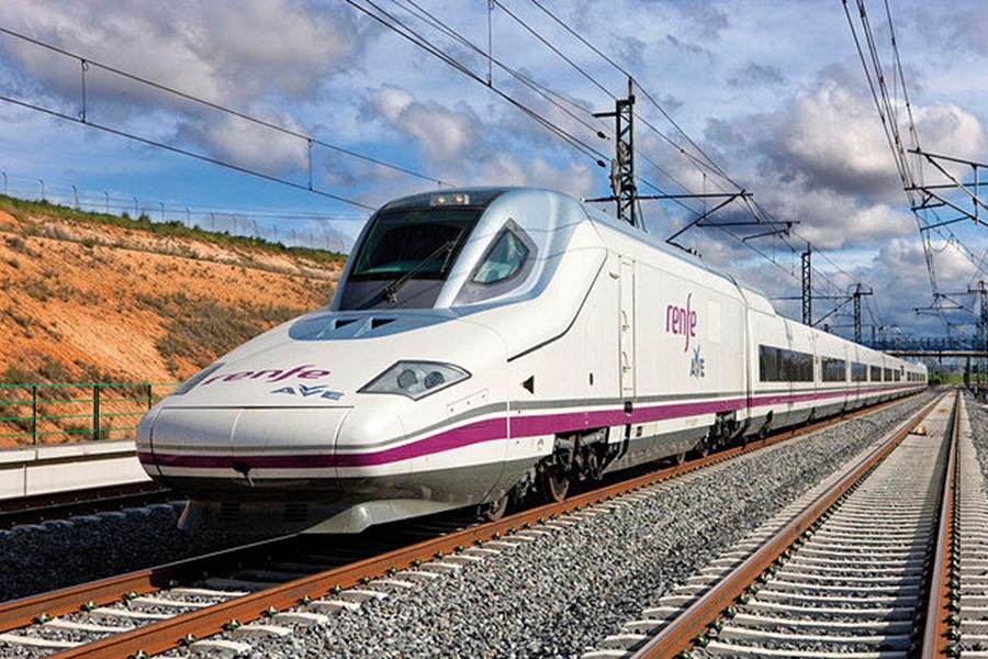 High-speed Renfe AVE train on tracks in Spanish countryside, showcasing modern rail technology.