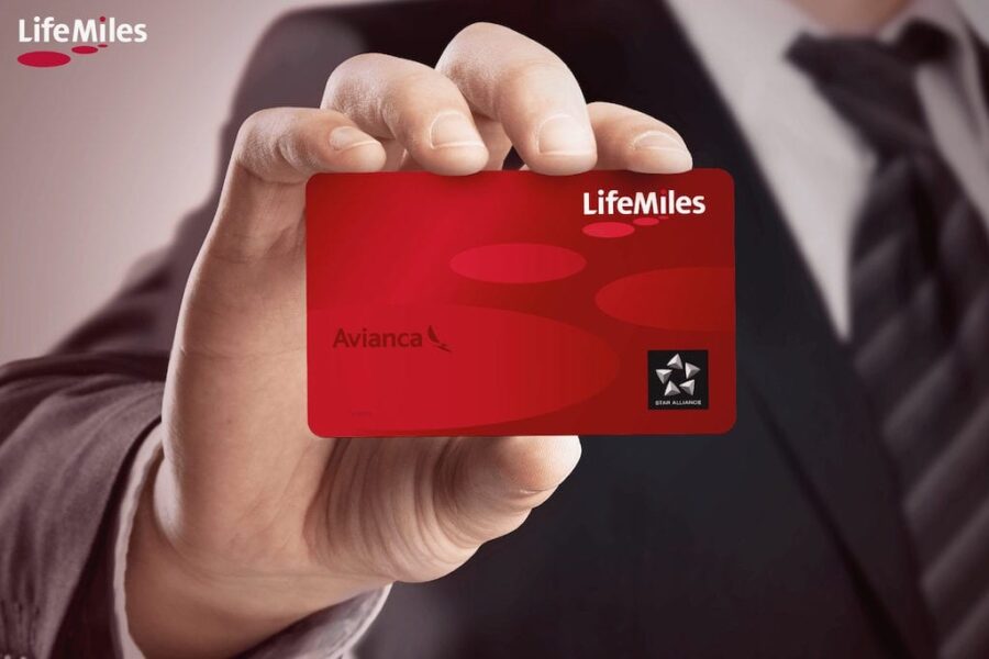 Avianca LifeMiles loyalty card held by a suited hand, emphasizing travel benefits and rewards.