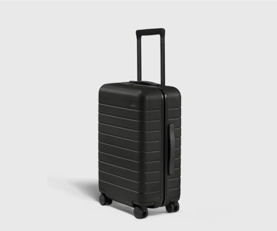 Black Away carry-on suitcase with wheels, displayed on a white background.