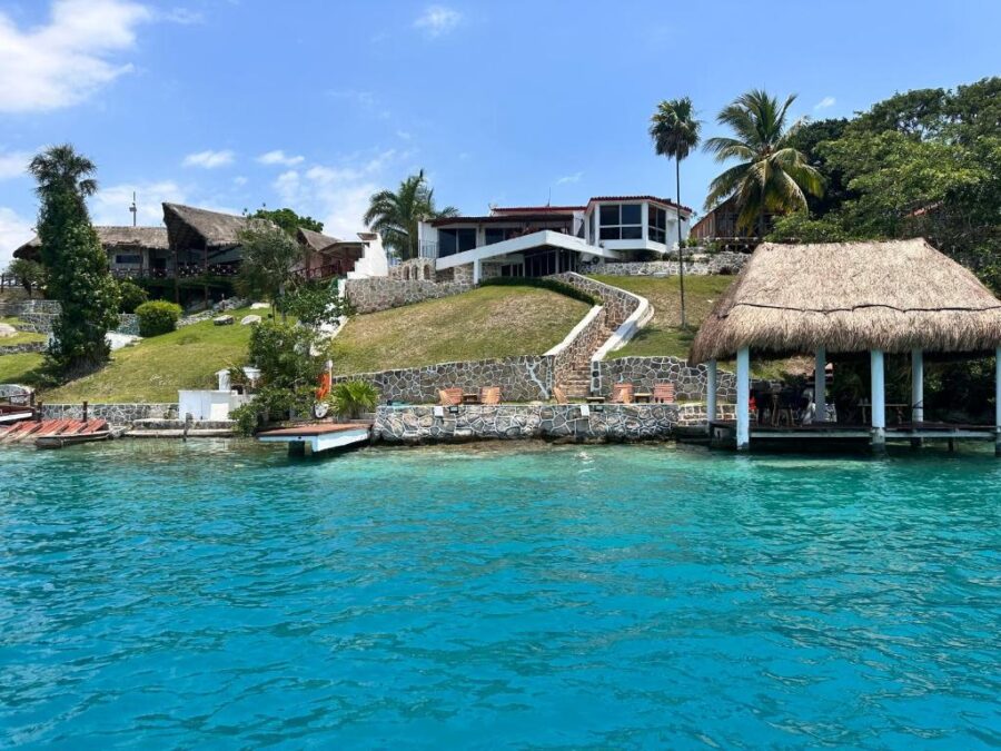Tatched-roof house of bacalar My Love Front Laguna Bacalar in Bacalar, Quintana Roo, Mexico, surrounded by serene blue lagoon waters.