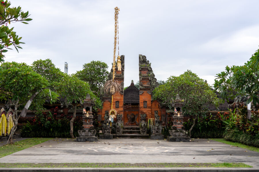 Large Balinese Angkul-angkul entrance gates with Bedogol gate guardians and offerings in front, set in Bali, Indonesia