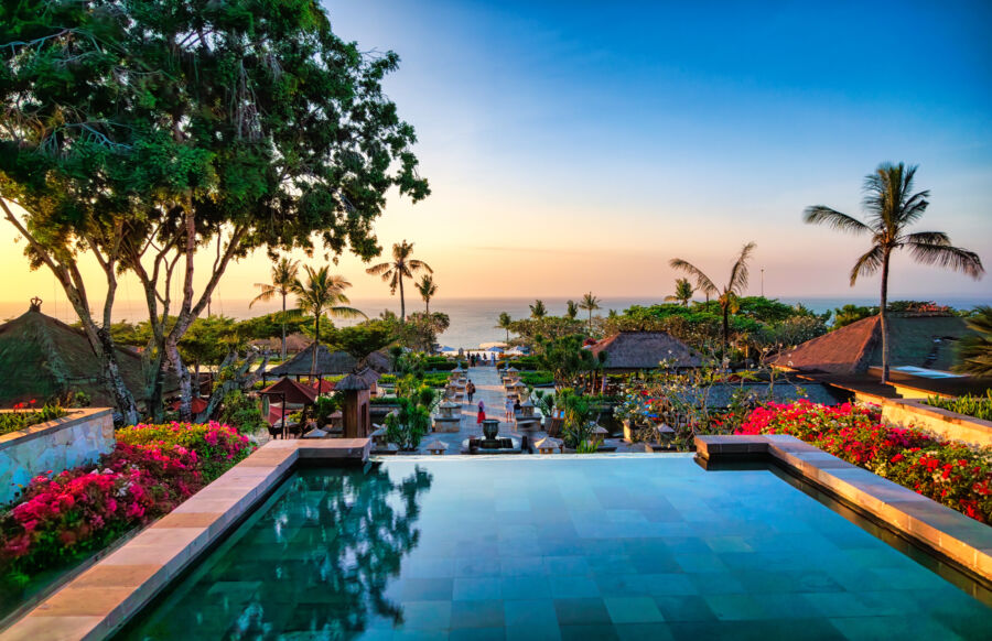 Sunset view over a Bali pool, showcasing vibrant colors and serene surroundings typical of Indonesia's tropical landscape