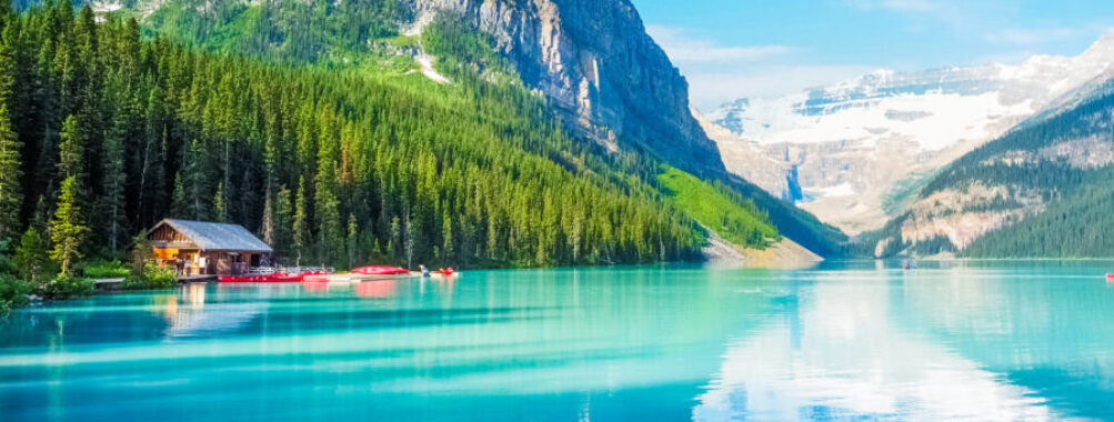 Scenic Lake Louise in Banff National Park, Canada, showcasing vibrant blue water and towering peaks in the background.