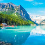 Scenic Lake Louise in Banff National Park, Canada, showcasing vibrant blue water and towering peaks in the background.