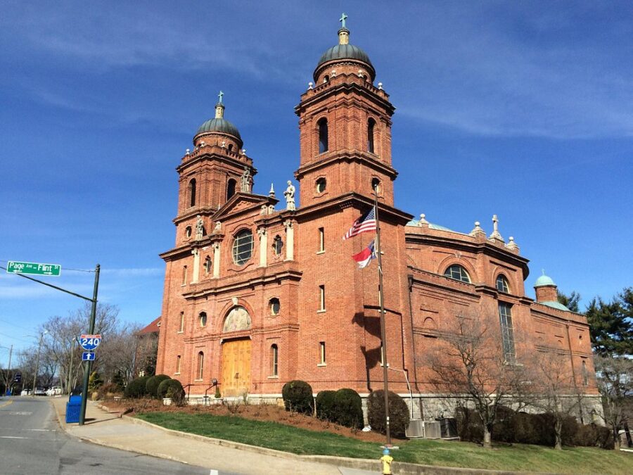 The Basilica of Saint Lawrence in Asheville, a large brick church with two striking towers, stands majestically.