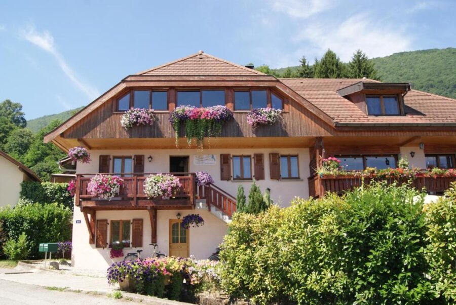 B&B Le Sourire du Lac in France features a house with vibrant flowers on its balcony.