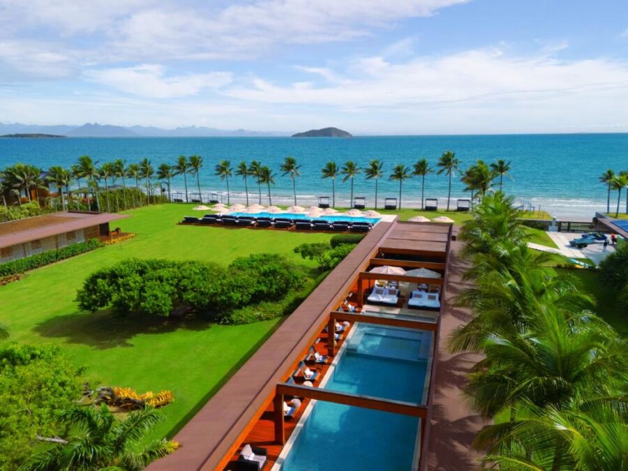 Luxury beachfront resort with infinity pool, palm trees, and ocean view at tropical spa destination.