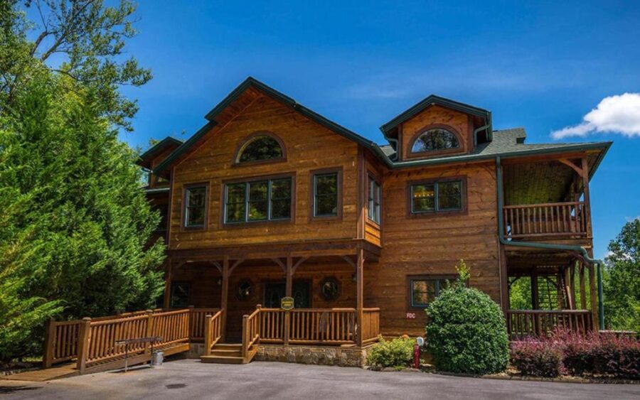 Large log home at Bearskin Lodge in Gatlinburg, featuring a spacious driveway and parking lot.