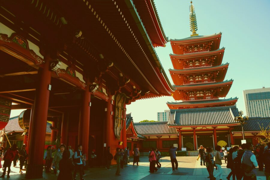 Senso-ji Temple pagoda and vermilion courtyard in Tokyo with visitors.