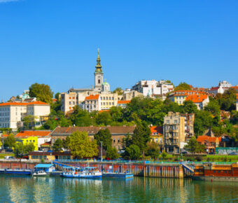 Scenic Belgrade skyline from the Sava River, with tourist boats enjoying a sunny day in Serbia.