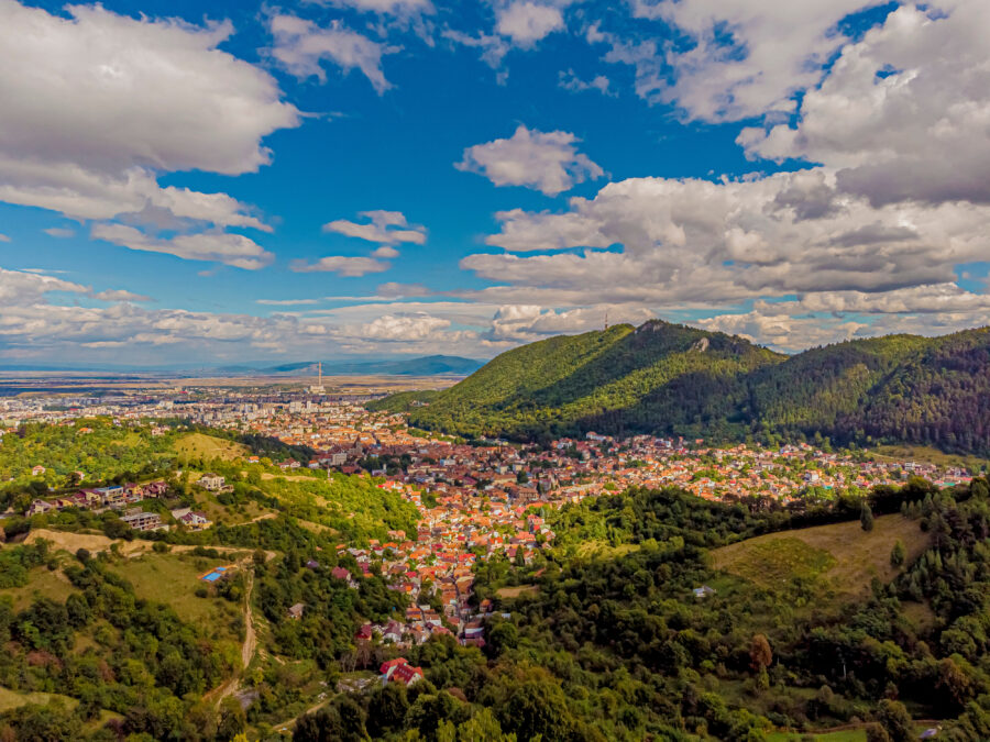 Scenic panorama of Brasov, Romania from Belvedere, highlighting the city and its mountainous backdrop.