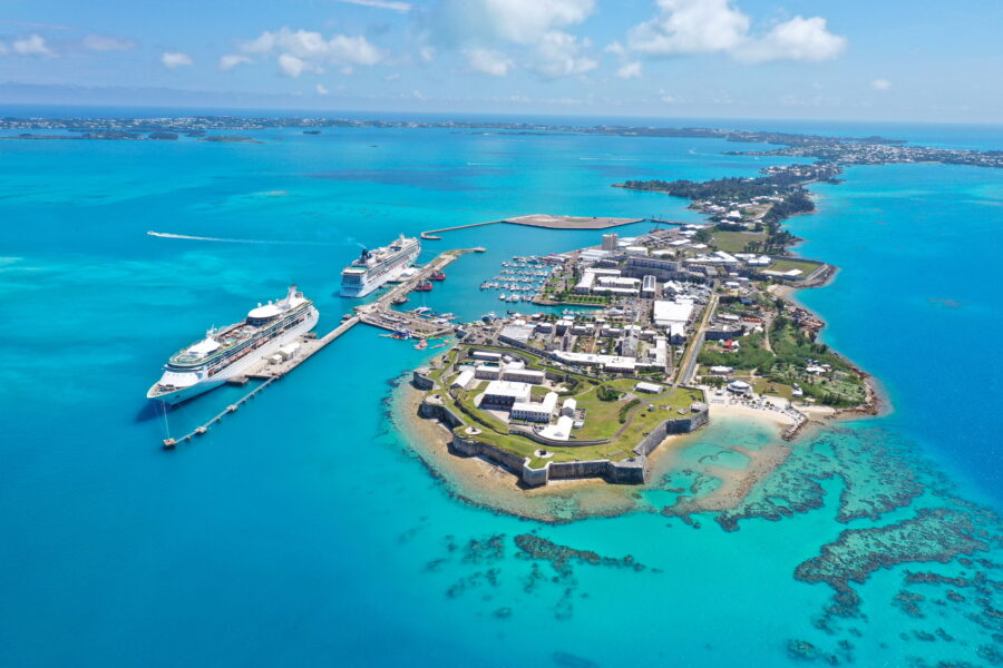 Aerial view of Bermuda, showcasing its lush greenery, turquoise waters, and sandy beaches in a tropical paradise setting.