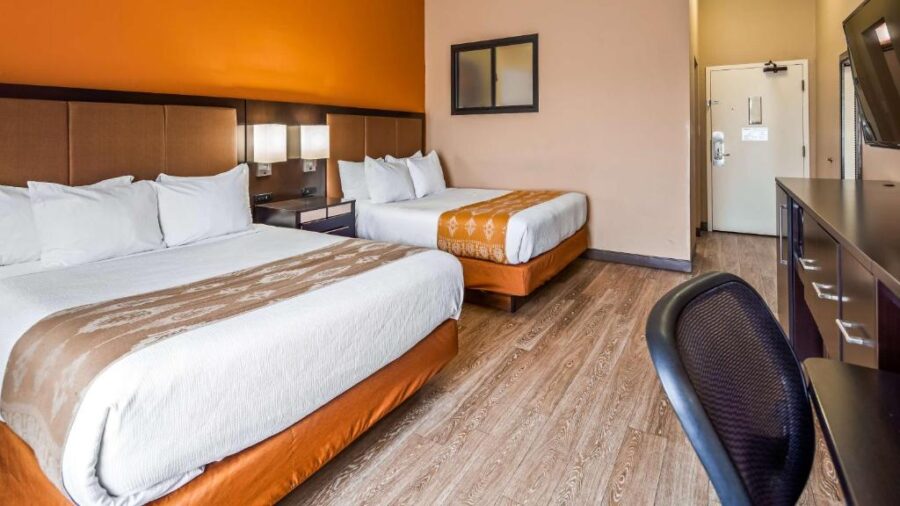 wo beds in a hotel room with orange walls at Best Western View of Lake Powell Hotel, Arizona.