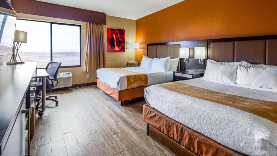Hotel room featuring two beds, orange walls, and a television at Best Western View of Lake Powell Hotel.
