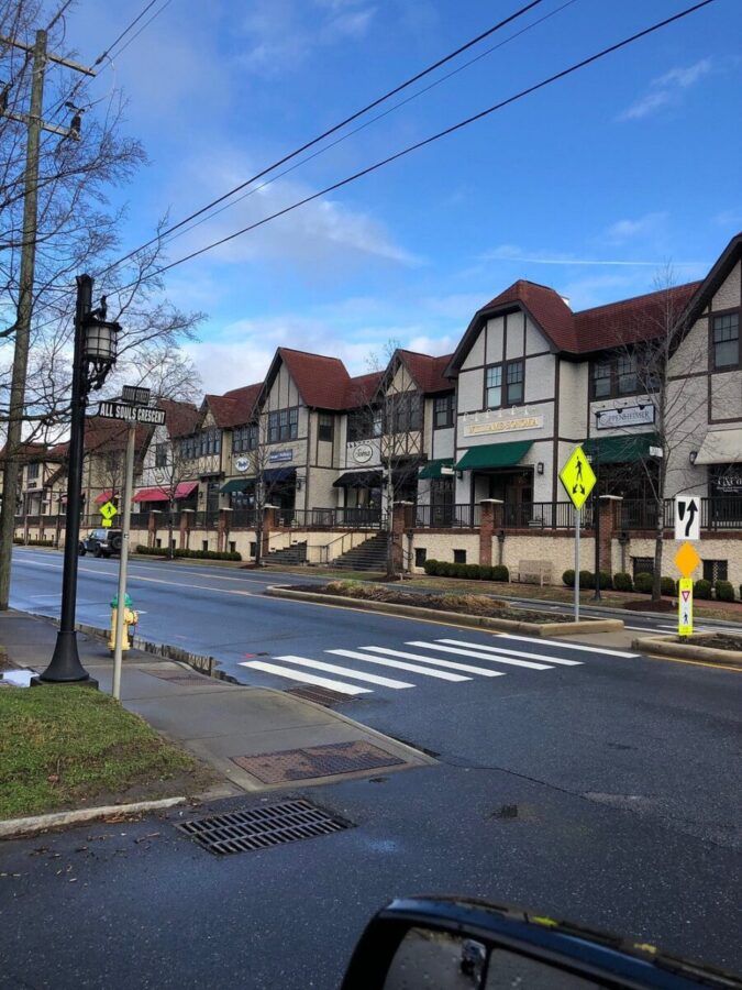 Street in Biltmore Village, Asheville, featuring a stop sign and a parked car.