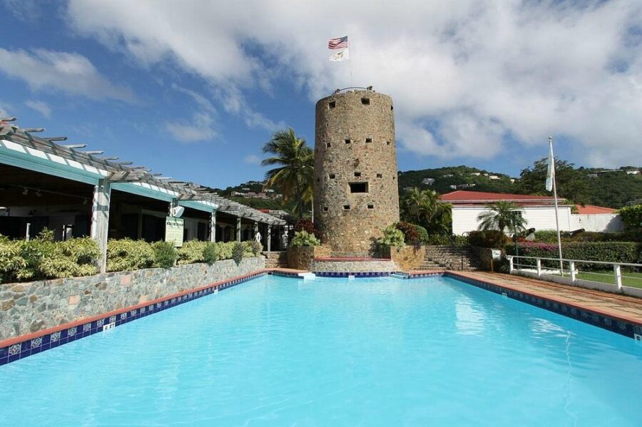 Spacious pool surrounded by greenery, featuring a prominent tower from Blackbeard’s Castle in St. Thomas.