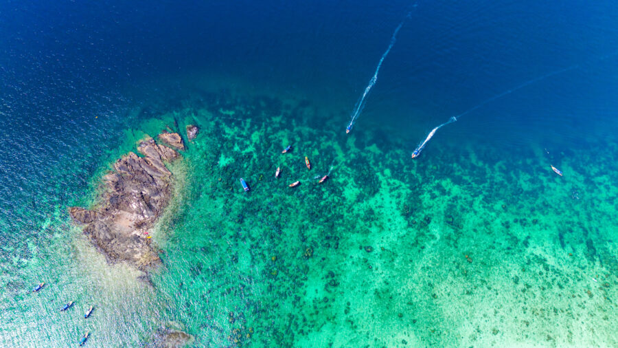 Aerial view of Blacktip Reef Shark Point, Phi Phi Island, with boats arriving at the popular snorkeling destination in Krabi, Thailand