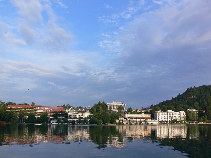 Scenic view of Bled Town, Slovenia, featuring a large body of water surrounded by a few buildings.