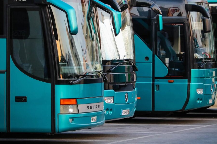 Modern turquoise buses, including SETRA and Mercedes, parked for urban travel readiness.