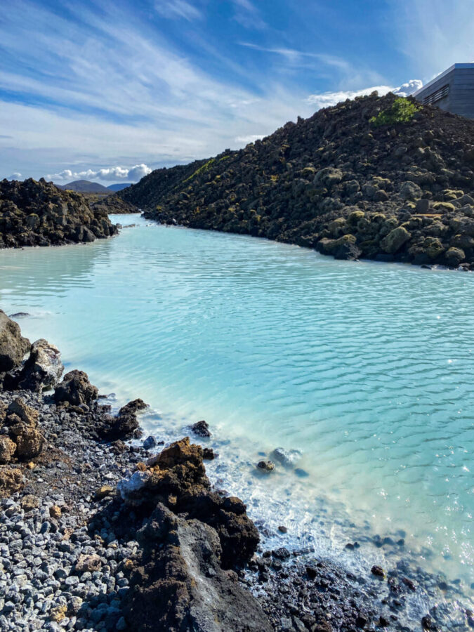 The Blue Lagoon in Iceland, showcasing vibrant blue waters and steam rising against a backdrop of dark volcanic rock