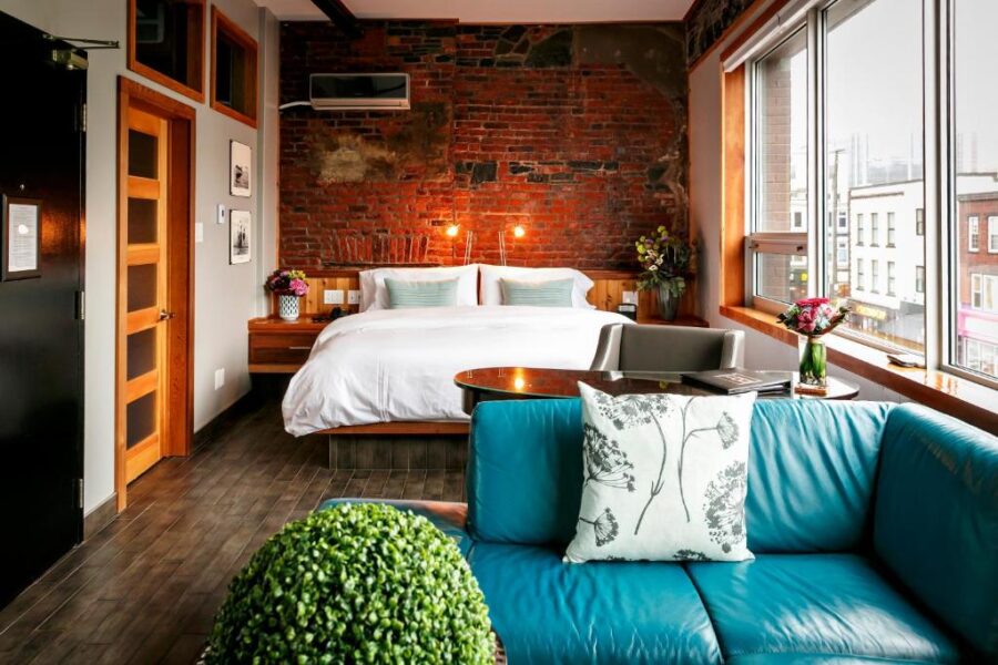 Well-furnished bedroom with a bed, couch, and window, situated in Blue on Water, St. Johns.