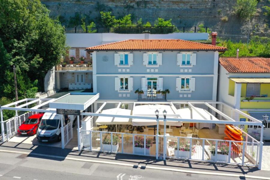 Blue Pearl Elite Apartments in Piran, Slovenia, featuring a car parked in front of the hotel entrance.