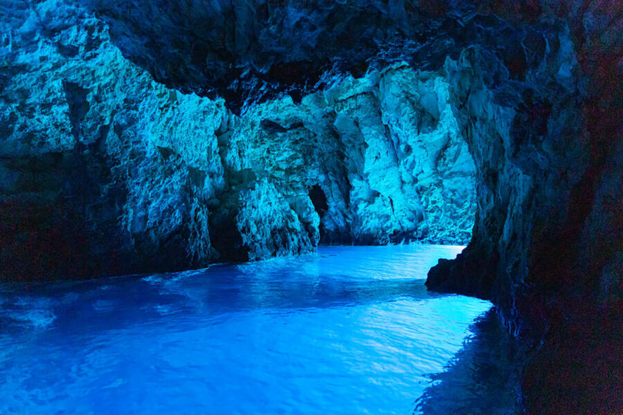 Blue Cave on Bisevo with luminous azure sea water inside a rocky cavern.