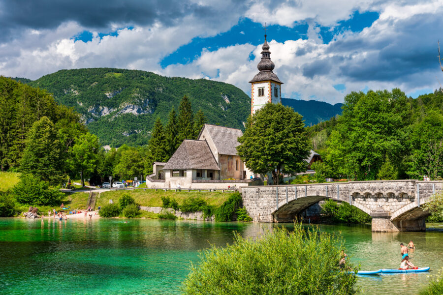 Aerial view of Bohinj Lake in the Julian Alps, featuring the Church of St. John the Baptist and Triglav National Park