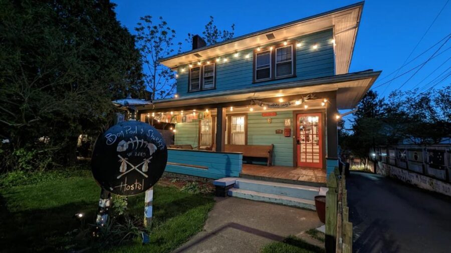 Bon Paul & Sharky’s Hostel in Ashville, showcasing a charming blue house with a white fence.