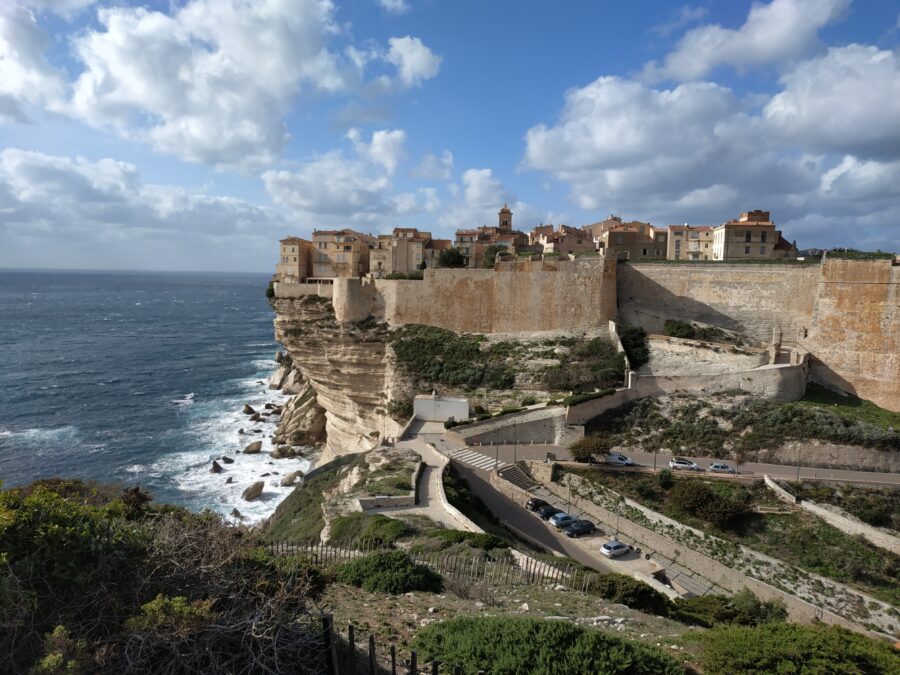Scenic cliffside view of Bonifacio, Corsica, highlighting the dramatic coastline and vibrant blue sea below.