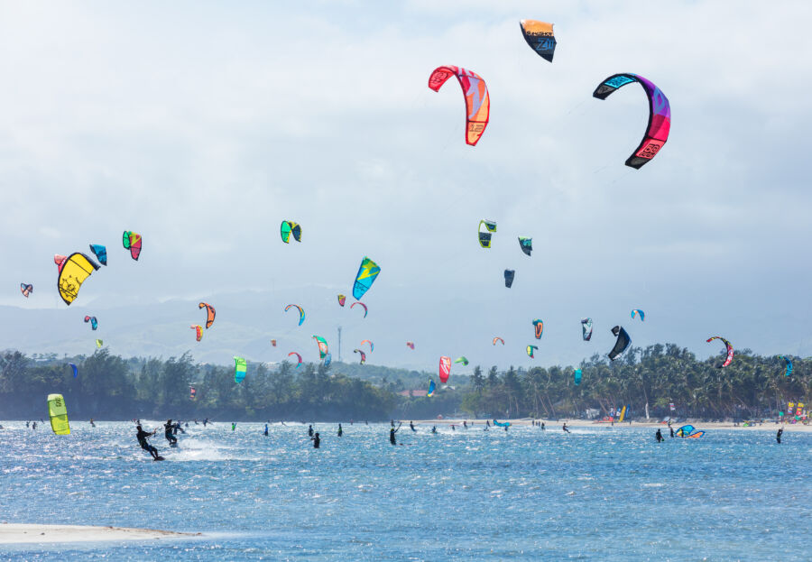 Kitesurfers on Bulabog Beach, Boracay, with colorful kites soaring above the sea, capturing the thrill of wind power