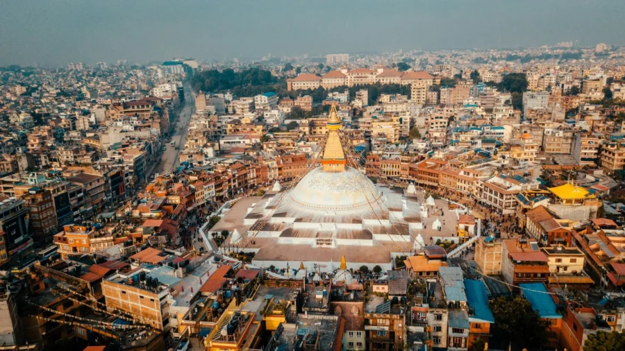 Aerial view of Boudhanath Stupa, Kathmandu: cultural landmark and bustling urban scenery.