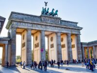 Brandenburg Gate in Berlin with tourists enjoying the iconic neoclassical monument.