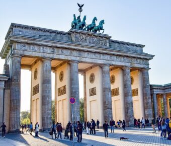 Brandenburg Gate in Berlin with tourists enjoying the iconic neoclassical monument.