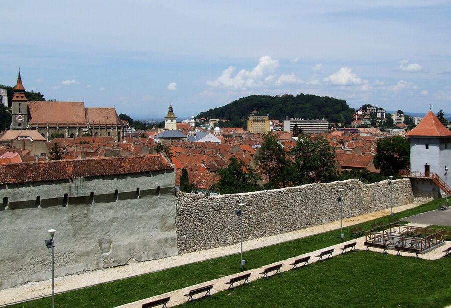 Scenic view of Brașov, Romania, highlighting the ancient city wall against a backdrop of urban landscape.